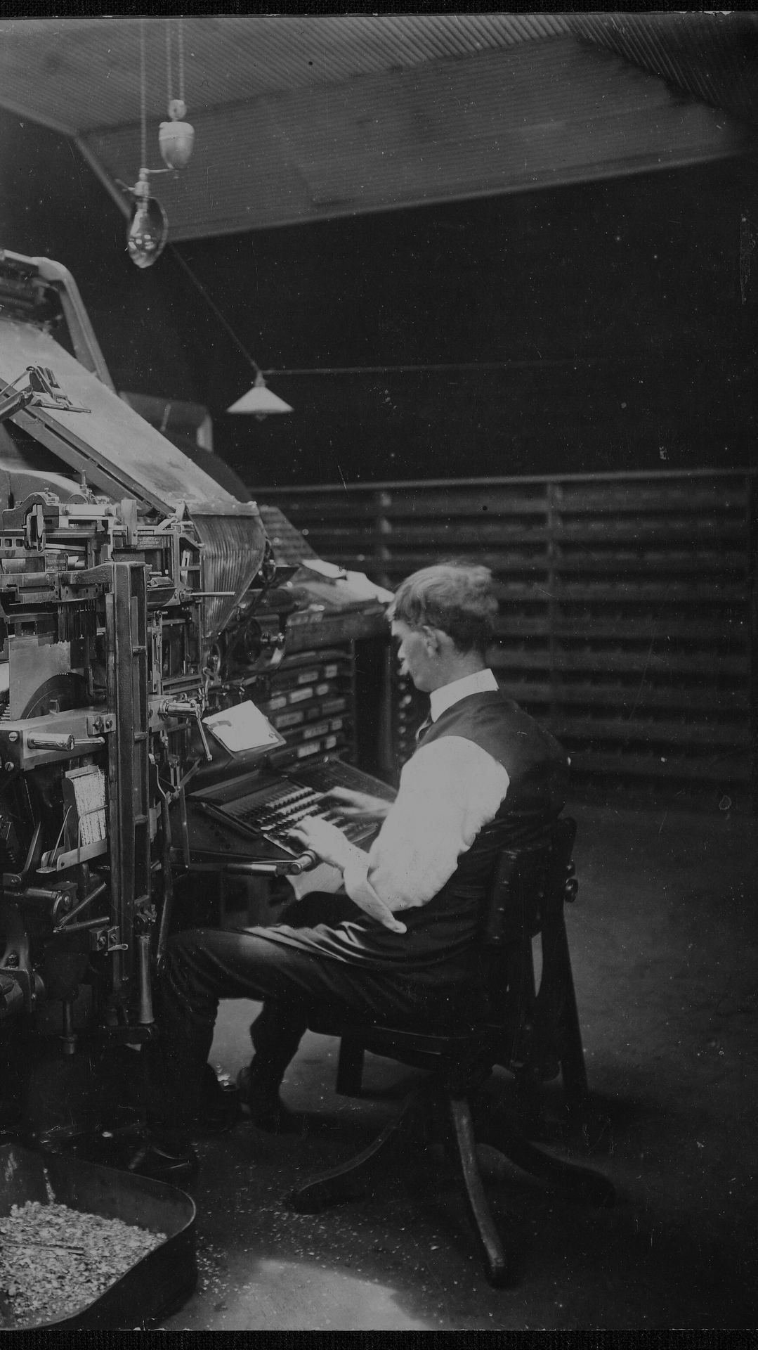 A man at a Linotype machine setting lines of type, around 1903.